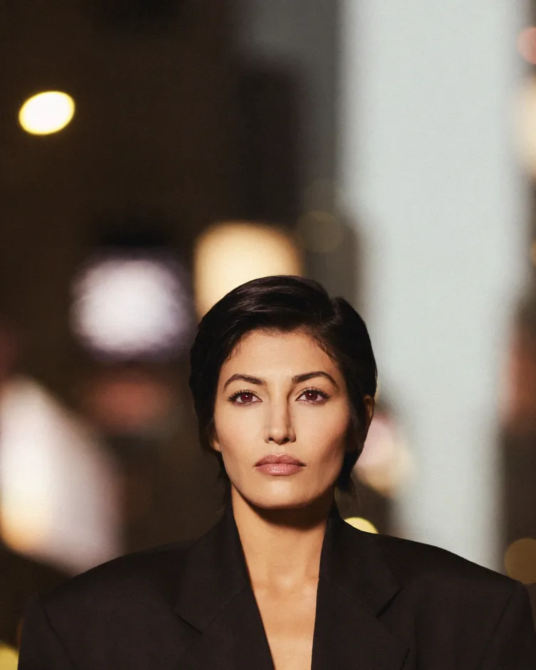Creative director at night with warm city lights behind her